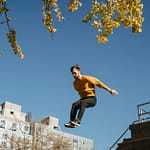 active man jumping from high structure